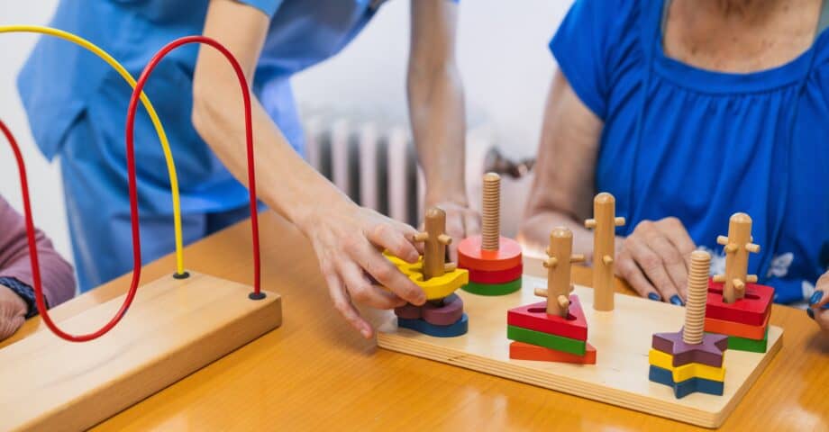 A caregiver and a resident participating in a cognitive puzzle activity during one of the many scheduled senior living events designed for enrichment.