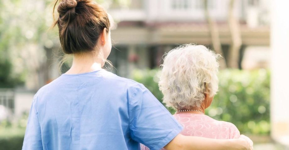 caregiver walking with elderly woman outdoor